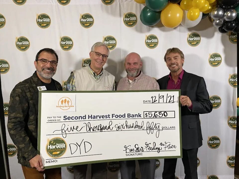 Four men holding big check
