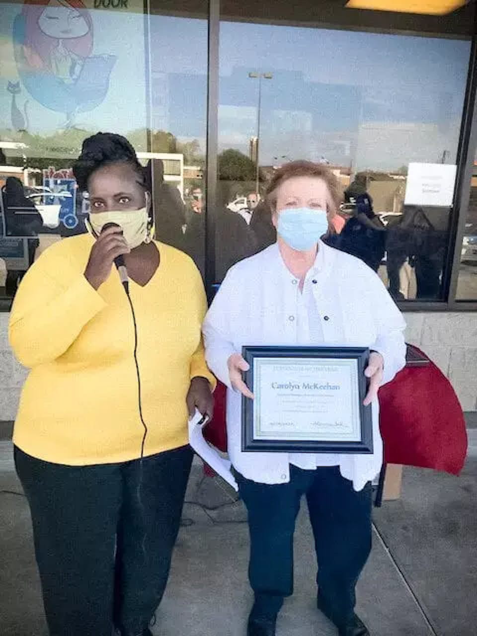 Two ladies holding an award