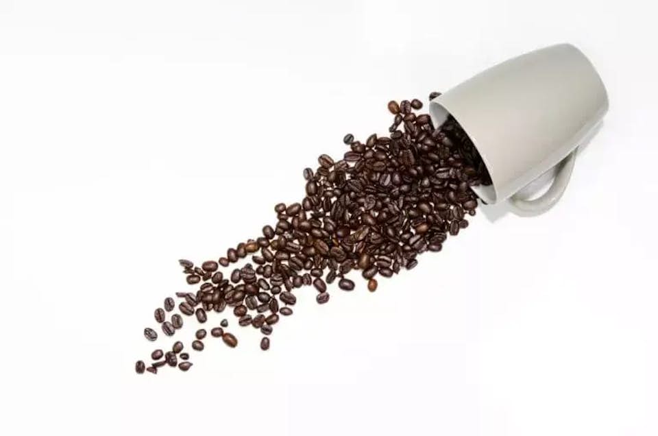 Mug spilling coffee beans