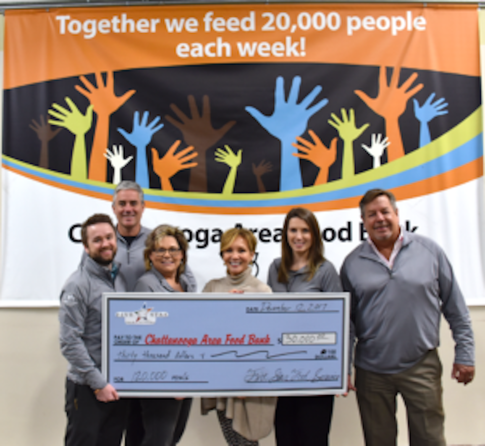 six people holding a big check for Feeding the Future