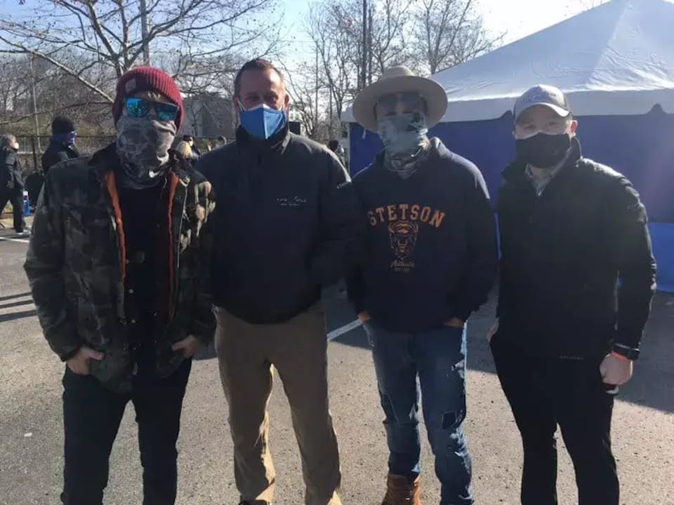 Four men wearing masks
